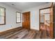 This bedroom has hardwood floors, a window with blinds, and an adjacent open door at 2402 Creekside Trce, Jonesboro, GA 30236