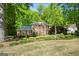Traditional brick home featuring a lush landscaped front yard and surrounded by mature trees at 2402 Creekside Trce, Jonesboro, GA 30236