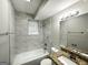 Renovated bathroom featuring new white tile, bathtub and shower combo with granite vanity at 3798 Bakers Ferry Sw Rd, Atlanta, GA 30331