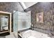 Luxurious bathroom featuring a jetted tub, glass-enclosed shower, and stylish wallpaper at 608 Wingspread, Peachtree City, GA 30269