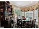 Charming dining area featuring a glass-top table, ornate hutch, and ample natural light from the backyard access at 608 Wingspread, Peachtree City, GA 30269
