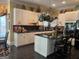 Open-concept kitchen with an island, white cabinets, hanging pot rack, and black tile floors at 608 Wingspread, Peachtree City, GA 30269