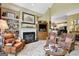 Cozy living room with a fireplace and built-in shelving, flowing into an open-concept kitchen area for a connected living space at 608 Wingspread, Peachtree City, GA 30269