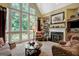 Bright living room with fireplace and large windows, offering scenic views and abundant natural light for a relaxing ambiance at 608 Wingspread, Peachtree City, GA 30269