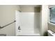 Bright white bathroom featuring white-tiled shower and tub with a window at 3865 Lehigh Blvd, Decatur, GA 30034