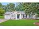 Charming one-story home with manicured lawn, attached garage, and mature trees providing shade at 3865 Lehigh Blvd, Decatur, GA 30034