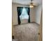 Cozy bedroom with plush carpeting, a ceiling fan, and a large window covered with green curtains at 3041 Regal Dr, Mcdonough, GA 30253