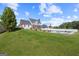 Expansive backyard featuring a well-maintained lawn, fenced pool area, and mature trees offering privacy at 125 Anna Dr, Covington, GA 30014