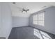This bedroom features a ceiling fan, a large window, gray carpet, and vaulted ceilings at 125 Anna Dr, Covington, GA 30014