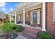 Charming front porch with brick steps, columns, and a welcoming door, perfect for relaxing outdoors at 125 Anna Dr, Covington, GA 30014