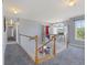 Upstairs hallway features natural light, neutral paint, wood and white banister, and gray carpet at 125 Anna Dr, Covington, GA 30014