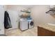 A functional laundry room with a modern washer and dryer, storage shelves, and a sink area at 125 Anna Dr, Covington, GA 30014