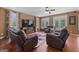 Cozy living room featuring hardwood floors, comfortable leather seating, and plenty of natural light with a ceiling fan at 125 Anna Dr, Covington, GA 30014