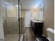Modern bathroom featuring a glass shower, double vanity, and wood-look flooring at 1853 Broad River Rd, Atlanta, GA 30349