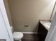 A half bathroom with a dark vanity and toilet at 1853 Broad River Rd, Atlanta, GA 30349