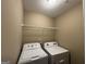 Laundry room featuring a washer and dryer with a rack above at 1853 Broad River Rd, Atlanta, GA 30349