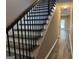 A modern staircase with wood steps, white risers and black metal railing, leading to the upper level at 1853 Broad River Rd, Atlanta, GA 30349