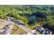Scenic aerial view showcasing a tranquil pond surrounded by lush greenery and beautiful neighborhood homes at 15 Dayton Way, Sharpsburg, GA 30277