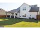 A large backyard with a covered patio, grass, and the rear exterior of the home at 15 Dayton Way, Sharpsburg, GA 30277