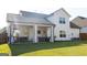 A large backyard with a covered patio, grass, and the rear exterior of the home at 15 Dayton Way, Sharpsburg, GA 30277