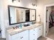 Bathroom with double sinks, granite countertops, white cabinetry, and a view into the walk-in closet at 15 Dayton Way, Sharpsburg, GA 30277