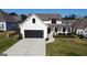 A beautiful two-story home is showcased, complete with a dark colored garage door and landscaped front yard at 15 Dayton Way, Sharpsburg, GA 30277