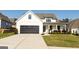 Beautiful exterior view of a two story home with a large black garage door and landscaped front yard at 15 Dayton Way, Sharpsburg, GA 30277