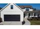 Lovely two-story home with black garage door, white siding and a charming front porch at 15 Dayton Way, Sharpsburg, GA 30277