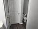 Half bathroom featuring tile floors, a white toilet, and a door to the left at 3015 Cranbrook Nw Walk, Kennesaw, GA 30144