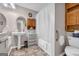 Bathroom featuring a pedestal sink, tub with a shower curtain, and wooden storage, blending practicality and functionality at 1326 Harmony Grove Church Rd, Auburn, GA 30011