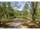View of the driveway lined with mature trees provides a scenic entrance to the property at 1326 Harmony Grove Church Rd, Auburn, GA 30011