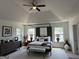 Bright main bedroom featuring a tray ceiling, a four-poster bed, and windows that flood the room with natural light at 2873 Shoals Hill Ct, Dacula, GA 30019
