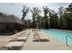 Community swimming pool with multiple lounge chairs and covered patio area at 2873 Shoals Hill Ct, Dacula, GA 30019