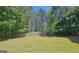 The backyard is surrounded by large trees for privacy and a wooden fence to define the yard at 109 Windsong Dr, Stockbridge, GA 30281