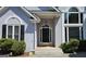 Inviting front entrance featuring a black door, sidelights, transom window, and manicured bushes at 109 Windsong Dr, Stockbridge, GA 30281