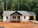 Charming single-story home with a welcoming front porch and an attached garage nestled amongst lush greenery at 22 Summer Ct, Carrollton, GA 30116