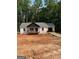 A charming single-story home featuring a welcoming front porch, an attached garage, and serene woodland surroundings at 22 Summer Ct, Carrollton, GA 30116