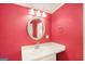 Bathroom with red walls, a mirror, vanity, and a three-bulb vanity light at 73 Highpoint Ln, Locust Grove, GA 30248