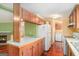 View of the kitchen featuring wood cabinets, countertops, a refrigerator, and an adjacent utility room at 73 Highpoint Ln, Locust Grove, GA 30248