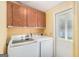 Laundry room with washer, dryer, storage cabinets, and a door that leads to the outside at 73 Highpoint Ln, Locust Grove, GA 30248