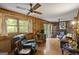 Cozy living room featuring wood paneling, natural light, and a brick fireplace at 6520 Rickenbacker Cir, Morrow, GA 30260