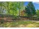 A backyard offers multiple levels with retaining walls, a basketball court, and mature trees offering shade at 3338 Hackmatack Dr, Kennesaw, GA 30152