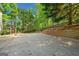 A sprawling backyard includes a concrete patio, tiered landscaping, mature trees, and wooden play structure at 3338 Hackmatack Dr, Kennesaw, GA 30152