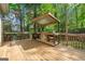 Wooden deck with a covered outdoor kitchen and grill perfect for entertaining at 3338 Hackmatack Dr, Kennesaw, GA 30152