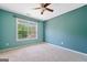 A peaceful bedroom with light blue walls, neutral carpet, and a window overlooking the greenery at 3338 Hackmatack Dr, Kennesaw, GA 30152
