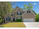 Charming two-story brick home with a well-manicured lawn and a two-car garage, set against a bright blue sky at 3338 Hackmatack Dr, Kennesaw, GA 30152