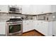 Well-equipped kitchen featuring granite countertops, stainless steel appliances and stylish backsplash at 3338 Hackmatack Dr, Kennesaw, GA 30152