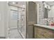 Bathroom featuring a sliding barn door, single sink vanity and tiled shower with glass doors at 202 Firefly Ct, Peachtree City, GA 30269