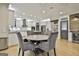 Dining room with hardwood floors open to kitchen area featuring a stone table and seating for four at 202 Firefly Ct, Peachtree City, GA 30269
