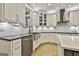 Clean kitchen with stainless steel appliances, farmhouse sink, white cabinets, and hardwood flooring at 202 Firefly Ct, Peachtree City, GA 30269